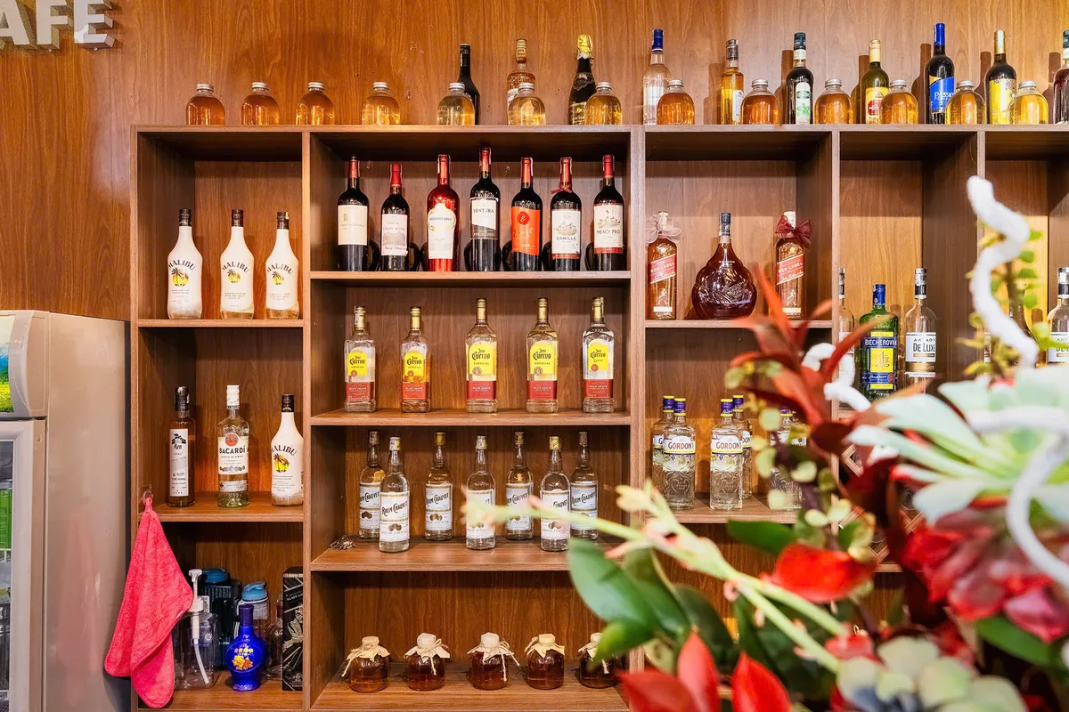 Wooden bar shelves and decorative flowers inside Vị & Thêu